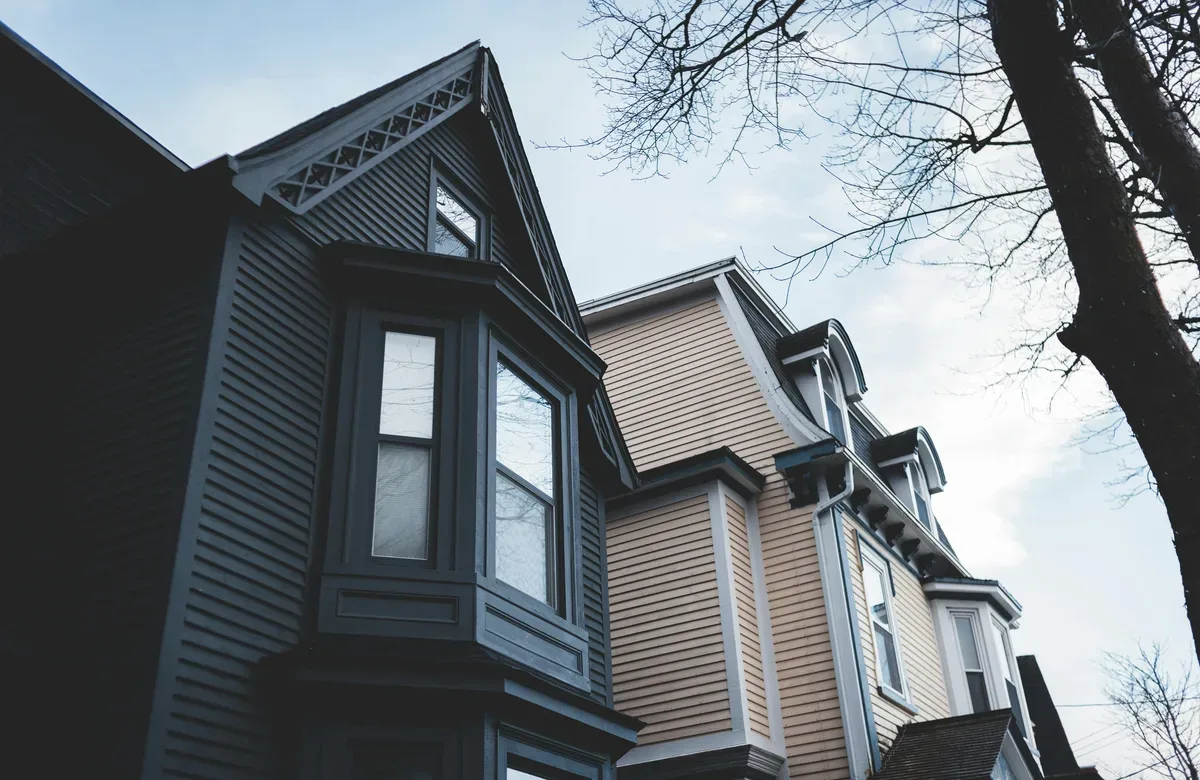 Older two-story home exterior with multiple white-framed windows